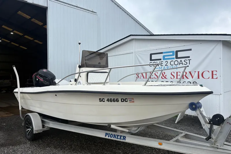 Slide: The Image of 1999 Sea Pro 180 Center Console boat on trailer outside marine service building. - 0