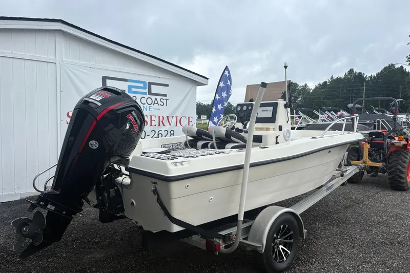 Slide: The Image of 1999 Sea Pro 180 Center Console boat on trailer, displayed outdoors near service building. - 1