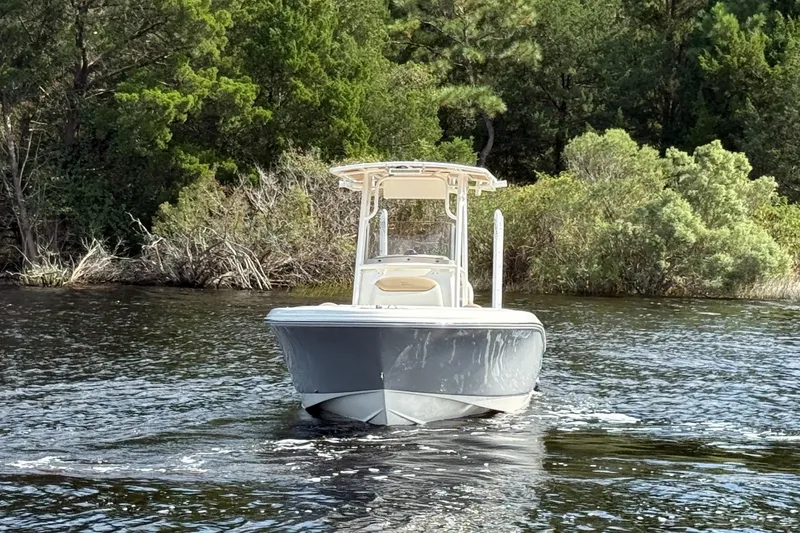 Slide: The Image of 2020 Pioneer 202 Islander boat cruising on a serene lake surrounded by lush greenery. - 3