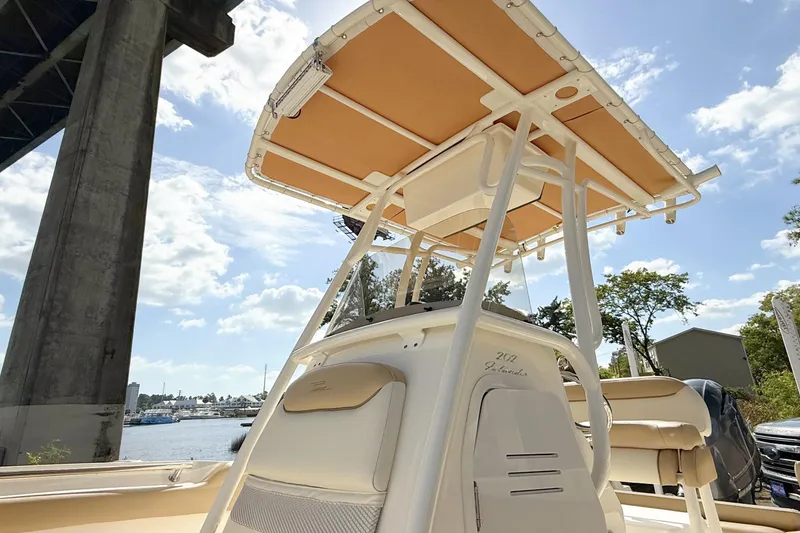 Slide: The Image of 2020 Pioneer 202 Islander boat under a bridge, showcasing its sleek design and canopy. - 5