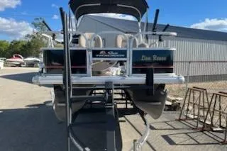 Slide: The Image of 2019 Sun Tracker Bass Buggy 16 DLX ET pontoon boat on trailer, outdoor setting. - 3