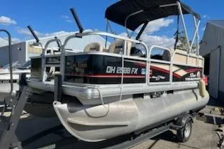 Slide: The Image of 2019 Sun Tracker Bass Buggy 16 DLX ET pontoon boat on trailer, outdoor setting. - 4