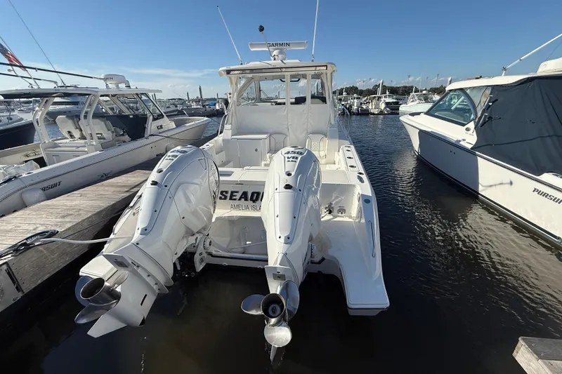 Slide: The Image of 2026 Pursuit OS 355 Offshore boat docked with twin outboard engines. - 10