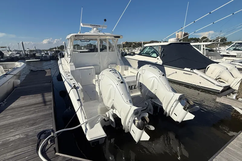 Slide: The Image of 2026 Pursuit OS 355 Offshore boat docked with twin Yamaha outboard engines. - 11