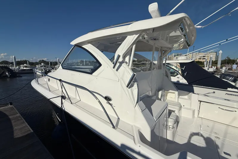 Slide: The Image of 2026 Pursuit OS 355 Offshore boat docked, showcasing sleek design and spacious deck. - 13