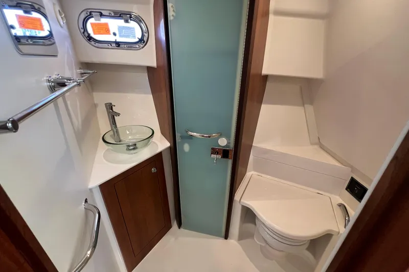 Slide: The Image of 2026 Pursuit OS 355 Offshore bathroom with glass sink and modern fixtures. - 18