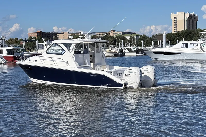 Slide: The Image of 2026 Pursuit OS 355 Offshore boat cruising in a marina with Yamaha engines. - 6
