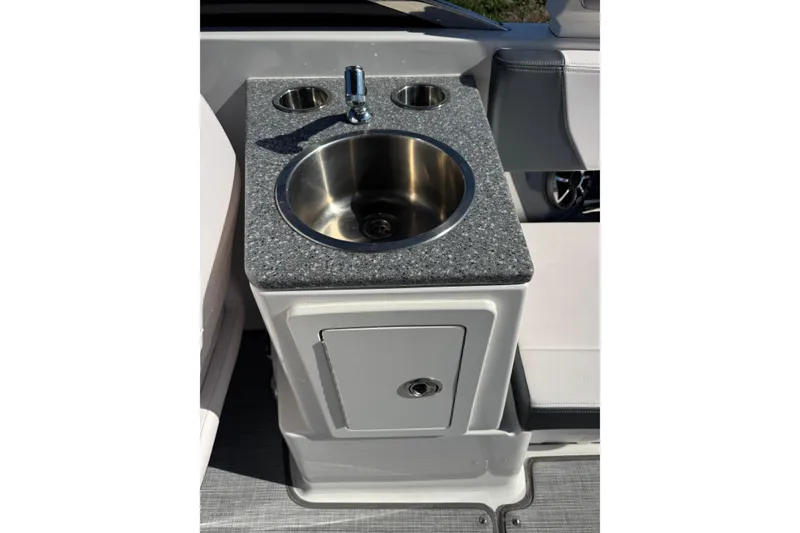 Slide: The Image of 2019 Chaparral 297 SSX boat sink with granite countertop and storage cabinet. - 23