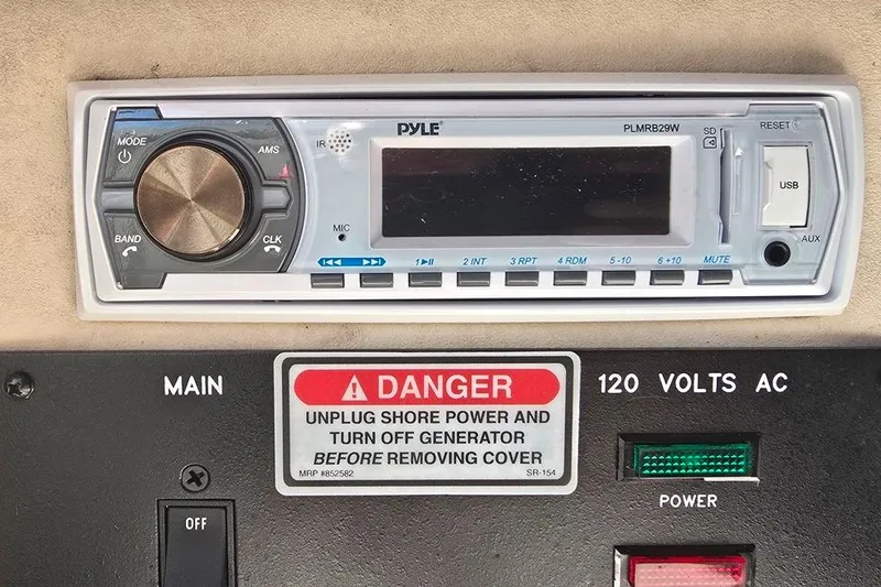 Slide: The Image of Pyle stereo system on 1997 Sea Ray 240 Sundancer boat dashboard with safety warning label. - 12