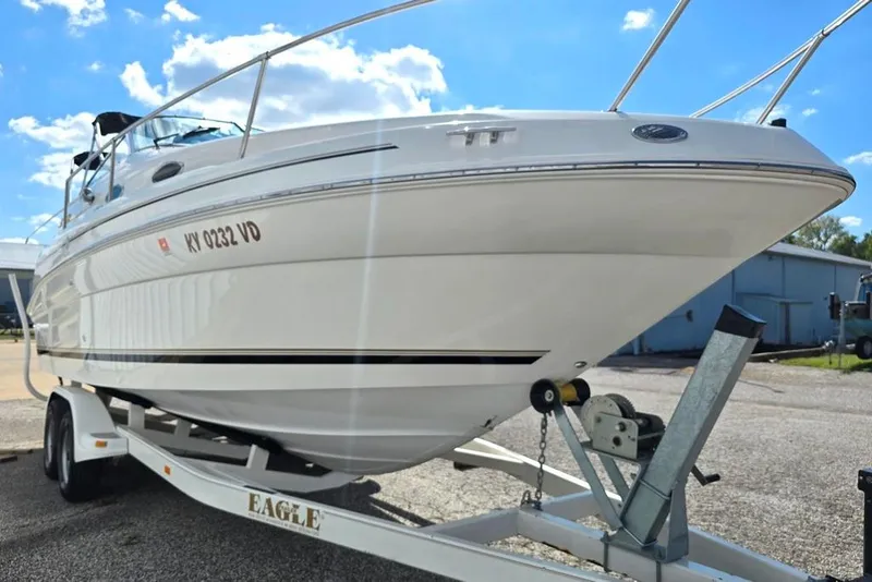 Slide: The Image of 1997 Sea Ray 240 Sundancer boat on trailer under a clear blue sky. - 13