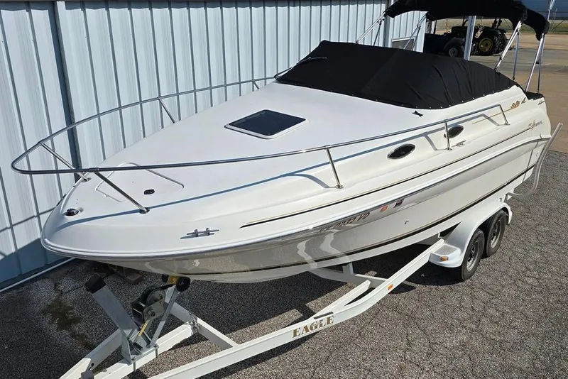 Slide: The Image of 1997 Sea Ray 240 Sundancer boat on trailer, parked outdoors. - 14