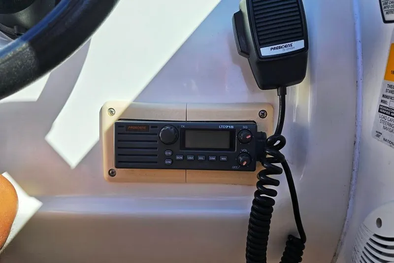 Slide: The Image of VHF radio and microphone on 1997 Sea Ray 240 Sundancer boat dashboard. - 23