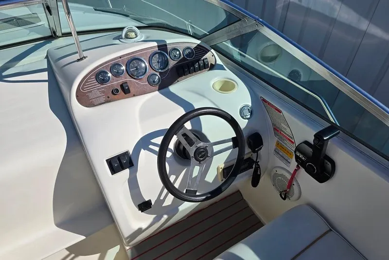 Slide: The Image of 1997 Sea Ray 240 Sundancer boat dashboard with steering wheel and control panel. - 3
