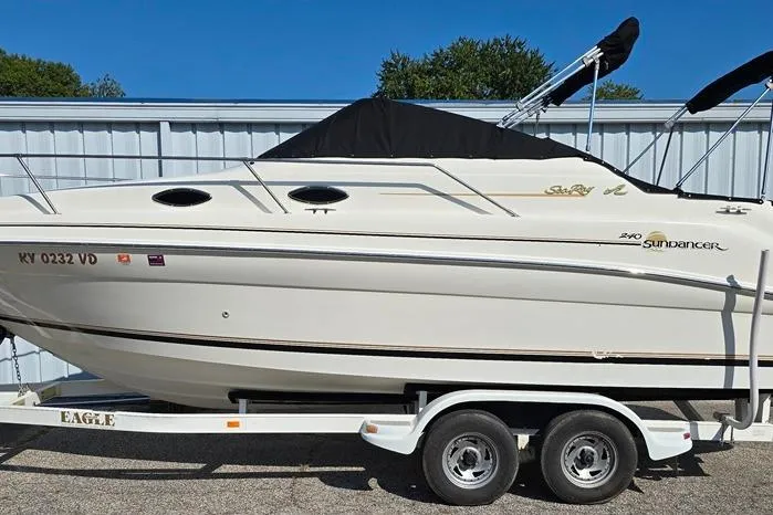 Slide: The Image of 1997 Sea Ray 240 Sundancer boat on trailer, parked outdoors. - 32