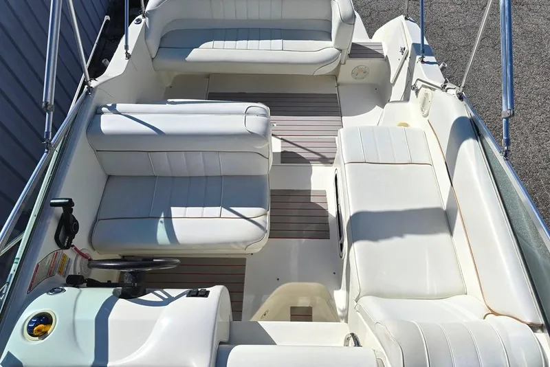 Slide: The Image of 1997 Sea Ray 240 Sundancer boat interior with white seating and steering wheel. - 4