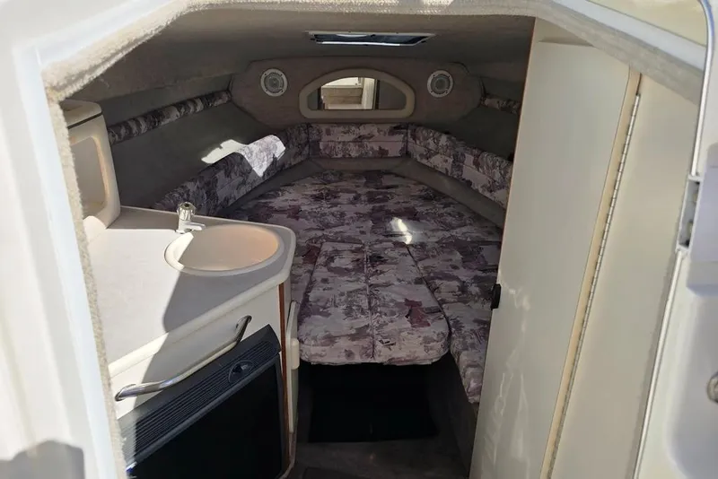 Slide: The Image of Interior cabin of 1997 Sea Ray 240 Sundancer with patterned seating and compact sink. - 6