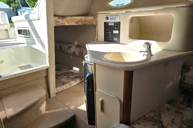 Slide: The Image of Interior of 1997 Sea Ray 240 Sundancer boat with kitchenette and seating area. - 7