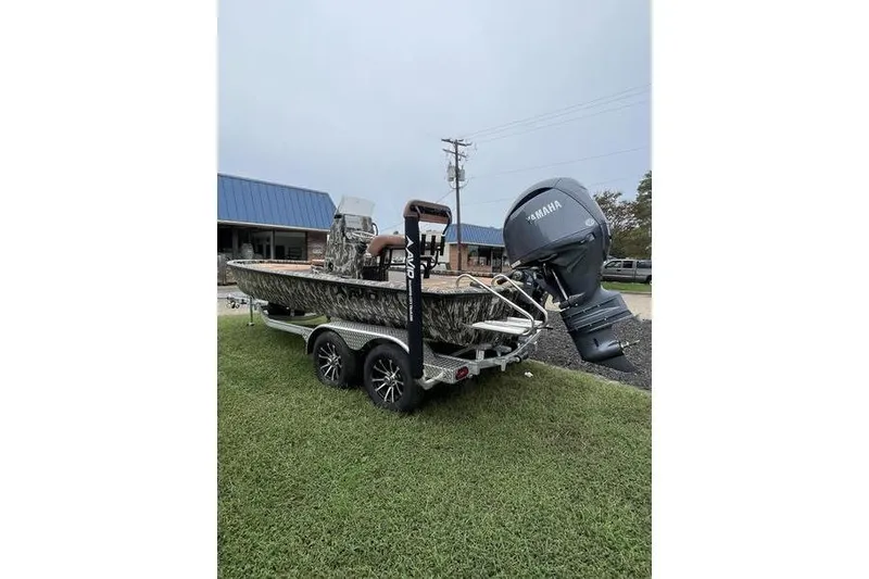 Slide: The Image of 2026 Avid 21 FSX boat on trailer with Yamaha outboard motor, parked on grass. - 1