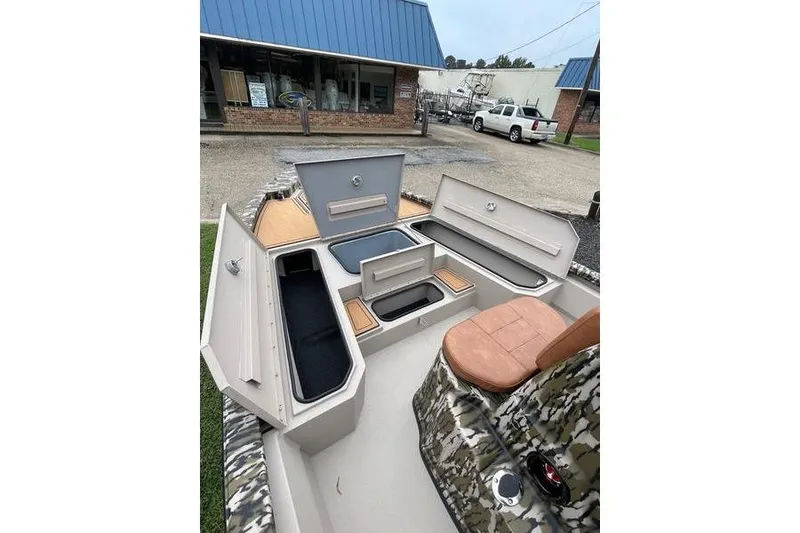 Slide: The Image of 2026 Avid 21 FSX boat interior with open storage compartments and camo seating. - 13