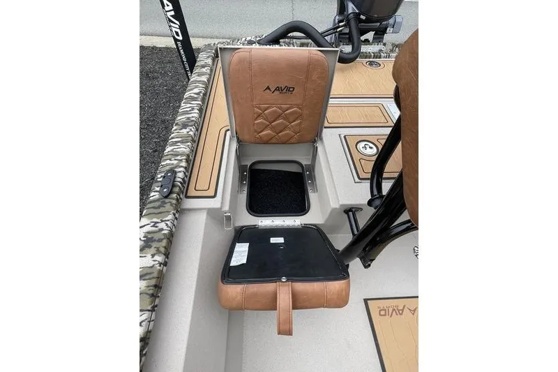 Slide: The Image of 2026 Avid 21 FSX boat seat with storage compartment open, featuring brown upholstery. - 16
