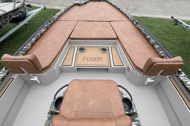 Slide: The Image of 2026 Avid 21 FSX boat interior with brown seating and Fusion audio system. - 3