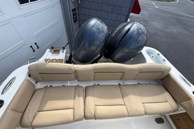 Slide: The Image of 2020 NauticStar 2602 Legacy boat with dual Yamaha engines and beige seating. - 15