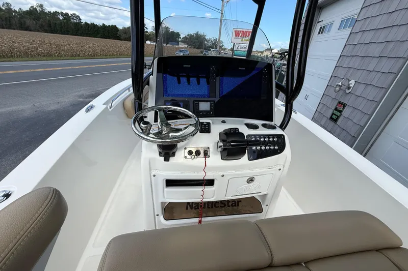 Slide: The Image of 2020 NauticStar 2602 Legacy boat dashboard with steering wheel and navigation controls. - 18