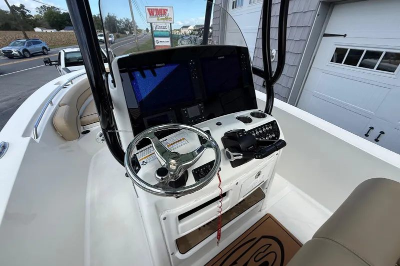 Slide: The Image of 2020 NauticStar 2602 Legacy boat helm with steering wheel and navigation controls. - 19