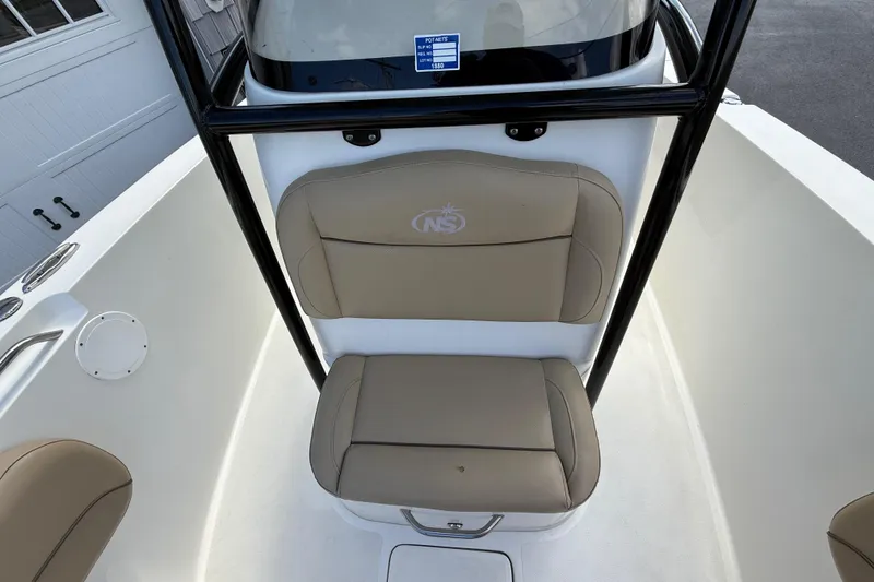 Slide: The Image of 2020 NauticStar 2602 Legacy boat seating area with tan cushions and black frame. - 25