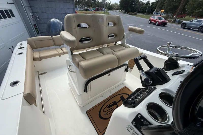 Slide: The Image of 2020 NauticStar 2602 Legacy boat interior with beige seating and control panel. - 26