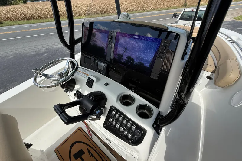 Slide: The Image of 2020 NauticStar 2602 Legacy boat dashboard with steering wheel and navigation screens. - 27