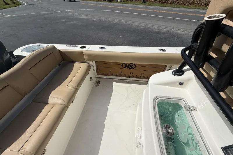 Slide: The Image of 2020 NauticStar 2602 Legacy boat interior with tan seating and measuring board. - 29