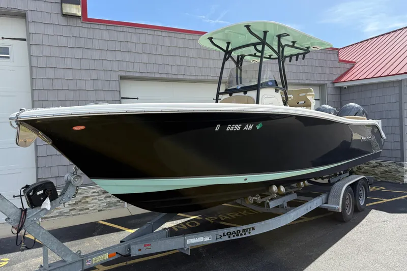 Slide: The Image of 2020 NauticStar 2602 Legacy boat on trailer, parked outside a building. - 3