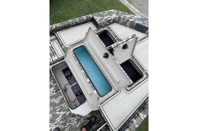 Slide: The Image of 2026 Avid 18 Commander boat storage compartments with camo design and organized interior layout. - 2
