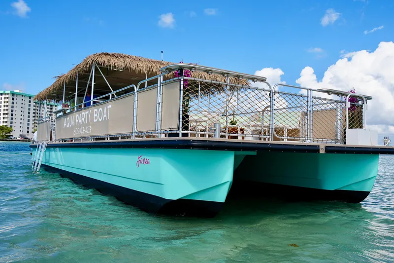 Slide: The Image of Aqua party boat, A&M Manufacturing Bulldog 43, 2027 model, on clear water under blue sky. - 4