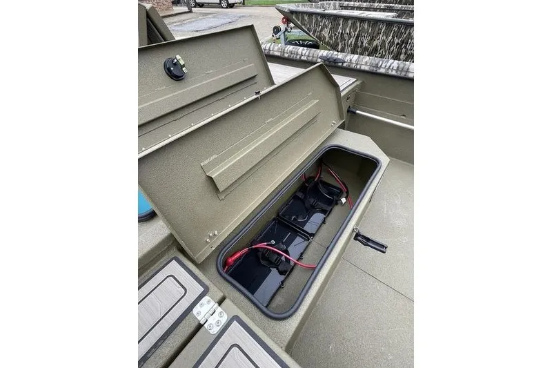 Slide: The Image of Open storage compartment in 2026 Avid 18 Commander boat, showing battery setup. - 3