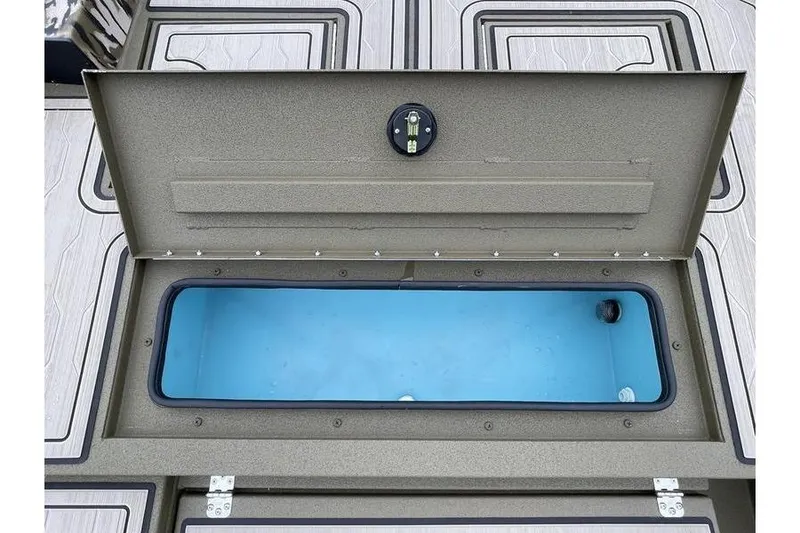 Slide: The Image of Open storage compartment on 2026 Avid 18 Commander boat, featuring a blue interior. - 8