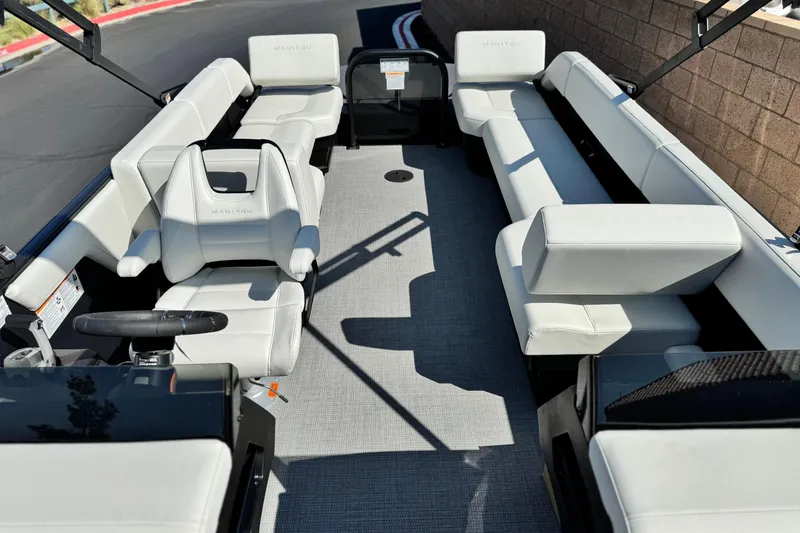 Slide: The Image of 2026 Manitou Cruise 22 Max pontoon boat interior with white seating and steering console. - 12