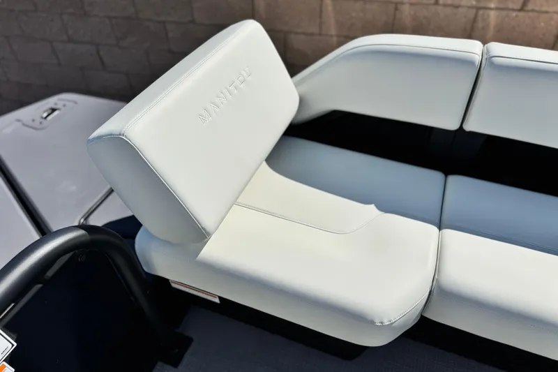 Slide: The Image of 2026 Manitou Cruise 22 Max boat seat with white upholstery and embossed branding. - 15