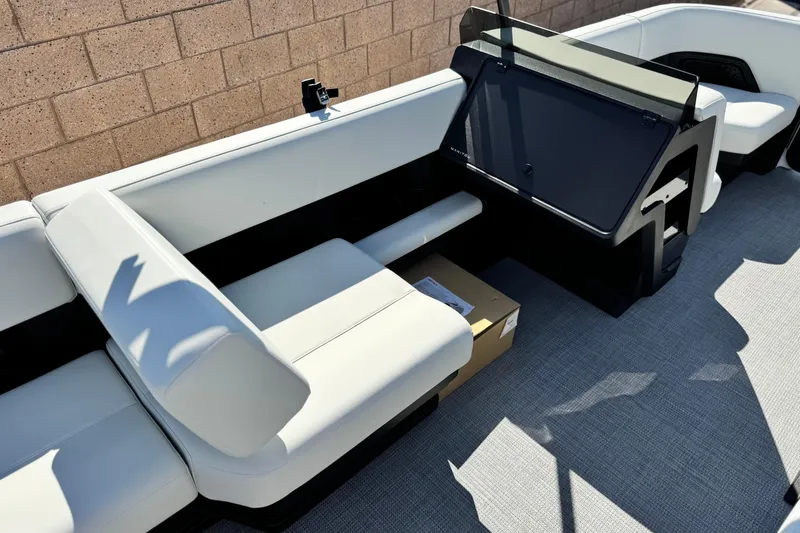 Slide: The Image of 2026 Manitou Cruise 22 Max boat interior with white seating and modern dashboard. - 22