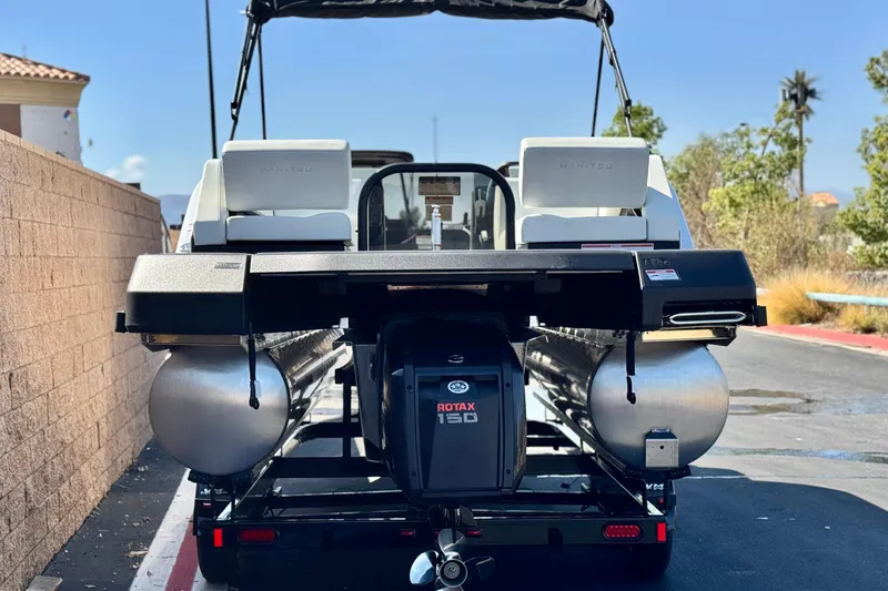 Slide: The Image of 2026 Manitou Cruise 22 Max pontoon boat with Rotax 150 engine, rear view. - 5