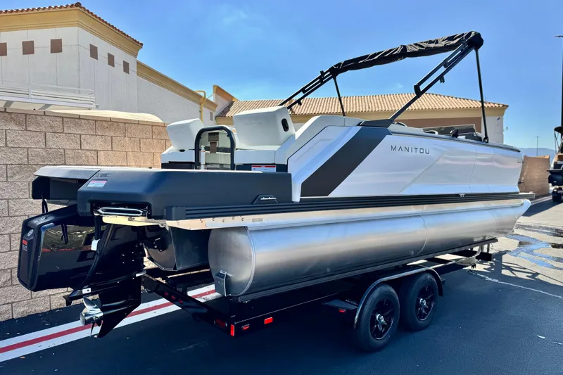 Slide: The Image of 2026 Manitou Cruise 22 Max pontoon boat on trailer, parked outdoors. - 6