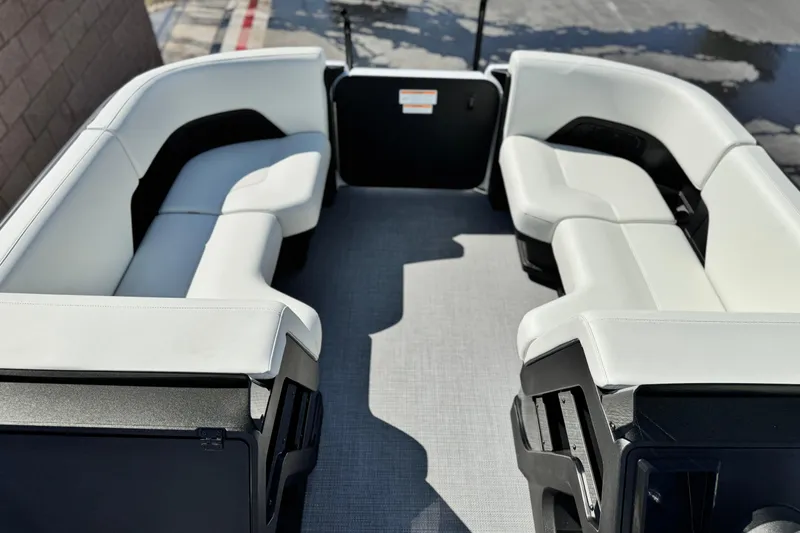 Slide: The Image of 2026 Manitou Cruise 22 Max pontoon boat interior with white seating and spacious layout. - 9