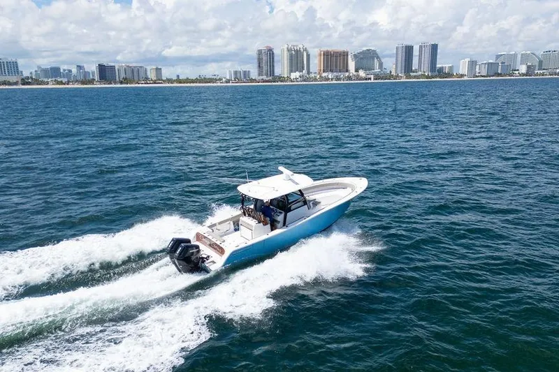 Slide: The Image of 2023 Sportsman Open 322 Center Console cruising on ocean near city skyline. - 12
