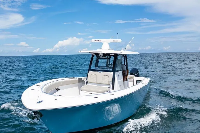 Slide: The Image of 2023 Sportsman Open 322 Center Console boat cruising on open ocean under blue sky. - 16