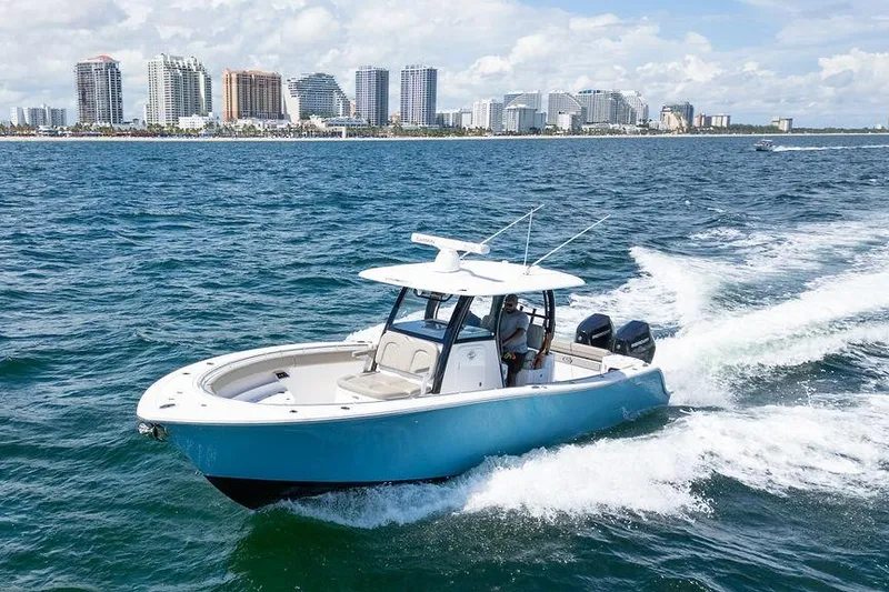 Slide: The Image of 2023 Sportsman Open 322 Center Console cruising on ocean near city skyline. - 20