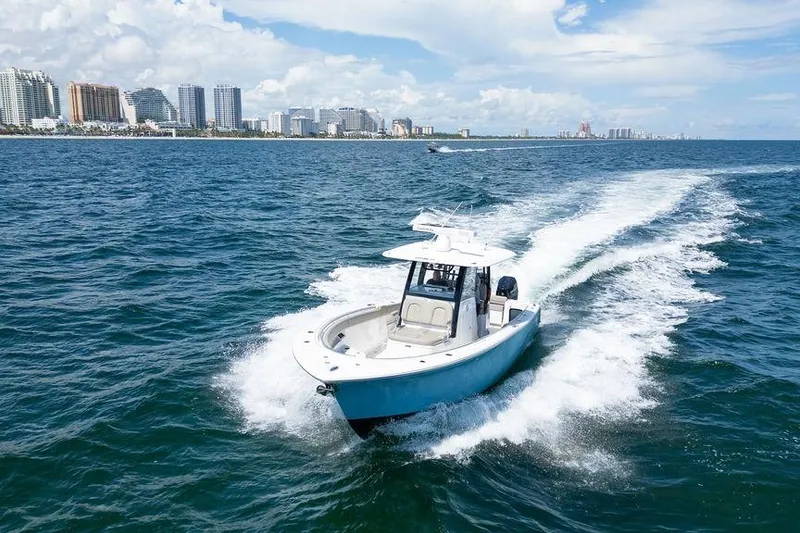 Slide: The Image of 2023 Sportsman Open 322 Center Console cruising on ocean near city skyline. - 21