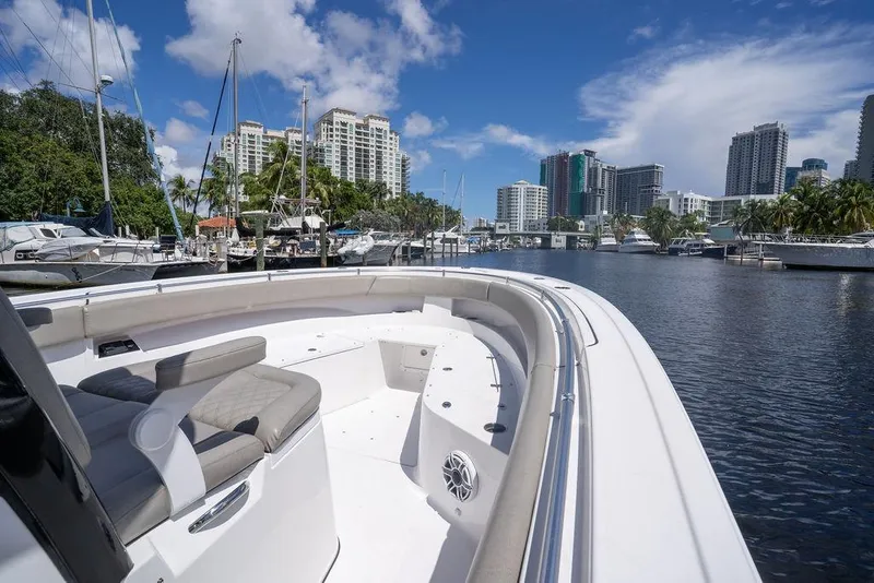 Slide: The Image of 2023 Sportsman Open 322 Center Console boat docked in a marina with city skyline. - 27
