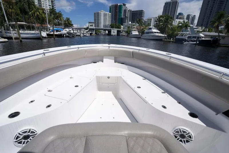 Slide: The Image of 2023 Sportsman Open 322 Center Console boat docked in a marina with city skyline. - 28
