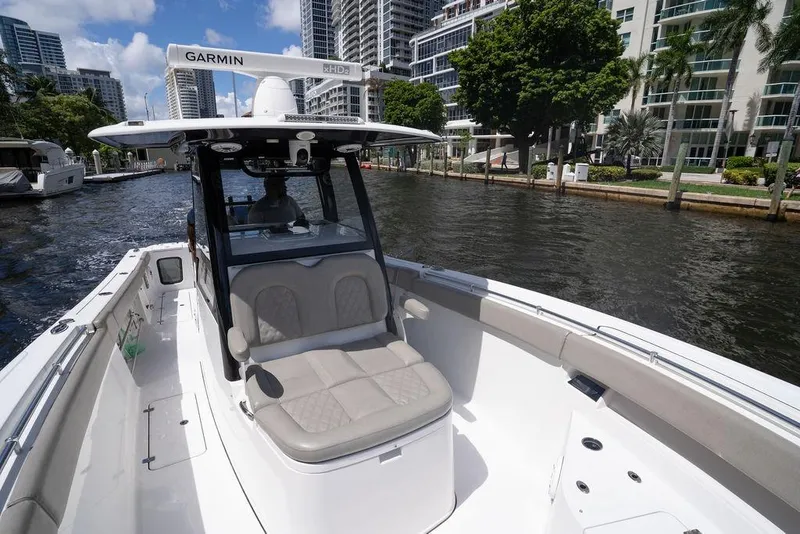 Slide: The Image of 2023 Sportsman Open 322 Center Console boat on a city waterway, featuring Garmin equipment. - 32